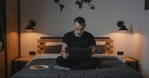 Joven concentrado frente a una laptop, absorbiendo conocimiento en una plataforma de microlearning.